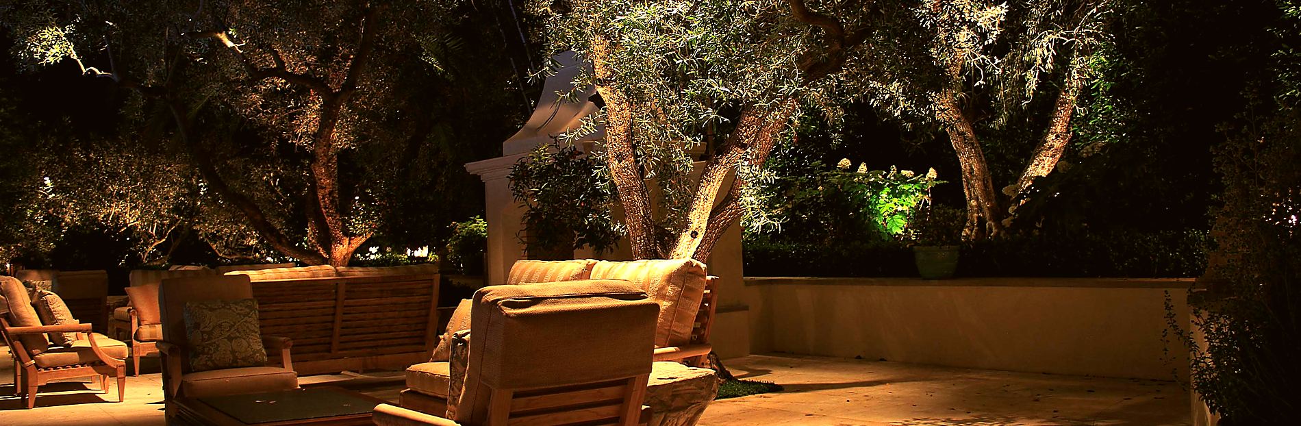 An outdoor fireplace lounge lit at night