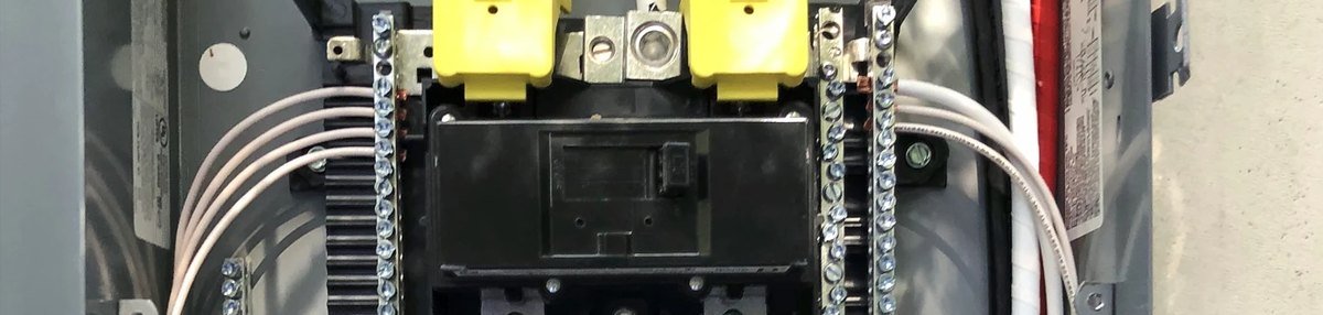 The inside of an electrical panel, with the main breaker and wiring