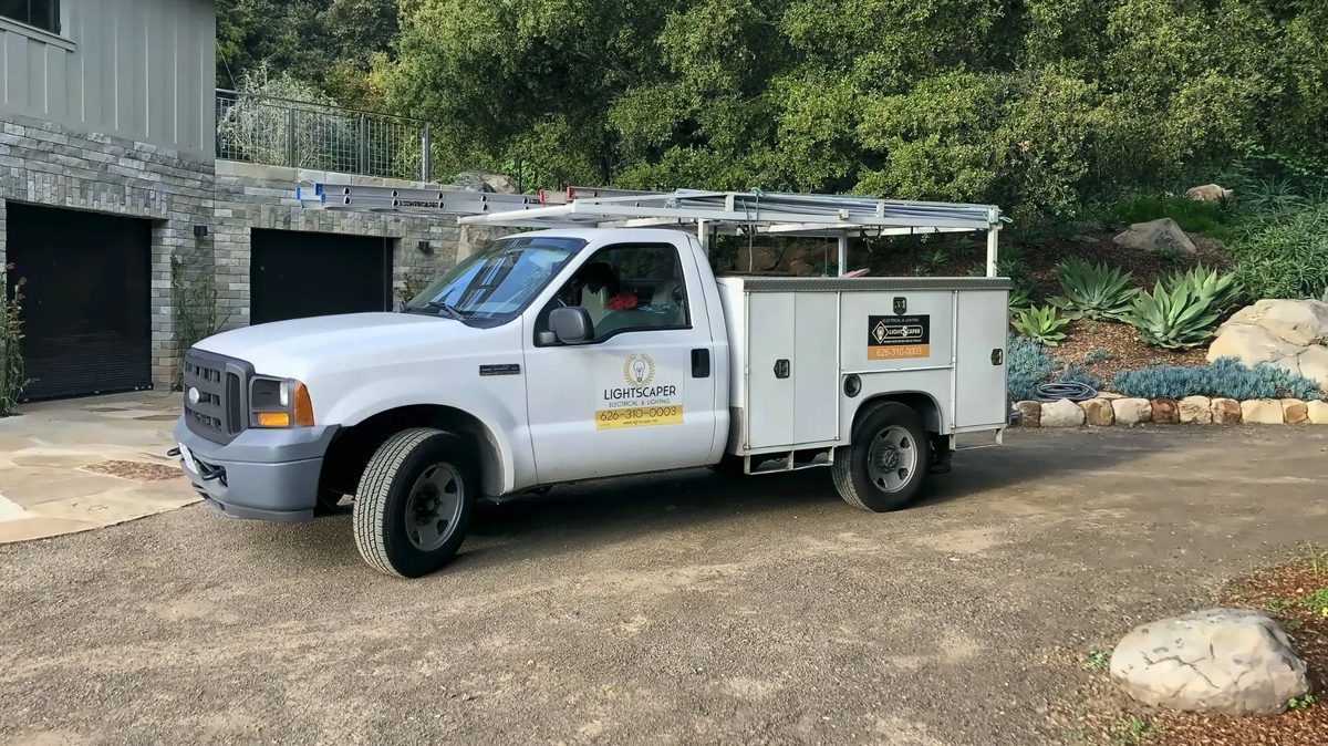 The LightScaper service truck with ladders, parked at a job