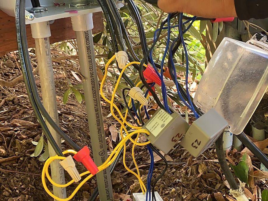 A technician testing relay modules in a junction box