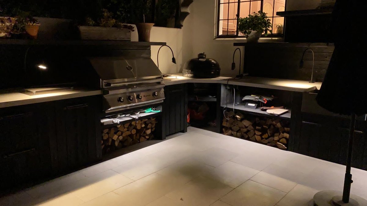 Outdoor kitchen lit at night with task and under-counter lighting