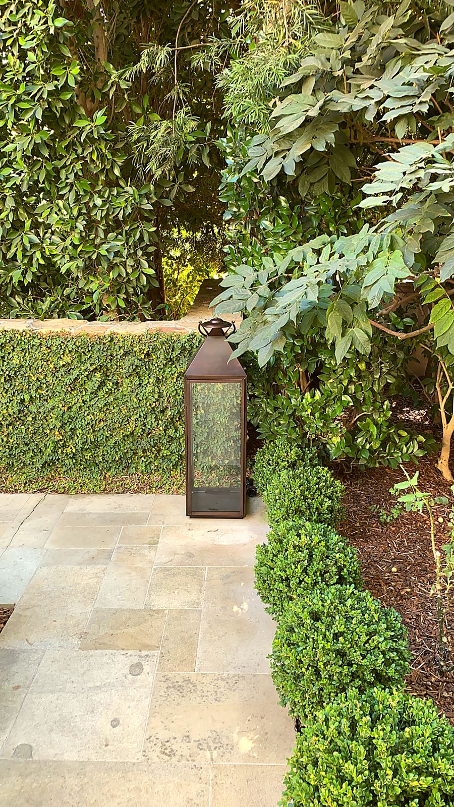 A bronze lantern set into a planted bed